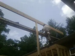 Carpenter setting a ridge beam over a new addition frame — Ice Dam Removal by Roofing Brothers in North Weymouth
