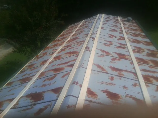 Rusted metal roof panels with new wood purlins before replacement — Storm Damage Roof Repair in North Weymouth by Roofing Brothers