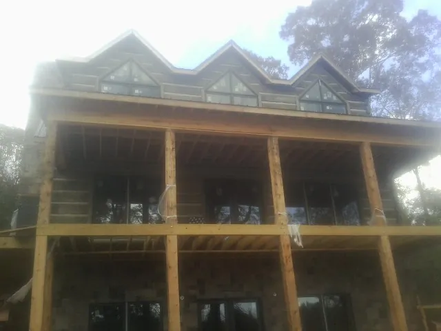 Dormers and porch framing on a large log home under construction — Roof Coating work by our crew in North Weymouth