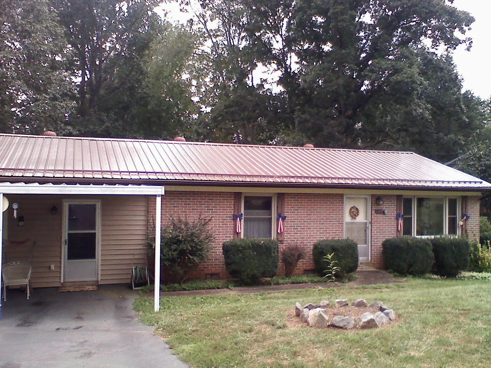 Bronze metal roof and carport on a brick ranch home — Roof Repair work by our crew in North Weymouth